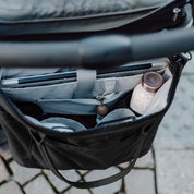 Wickeltasche Greta hängend am Kinderwagen mit extra großer Taschenöffnung für einen optimalen Überblick. 